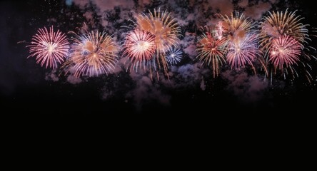 Vibrant fireworks explode in the night sky creating a spectacular display of colorful patterns and lights