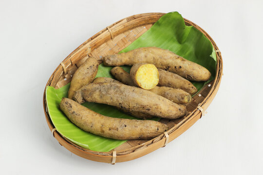 Umbi jalar rebus or steamed sweet potato. This tuber is beneficial for health because it contains fiber, vitamins, and minerals. Served on a bamboo plate with a white background.