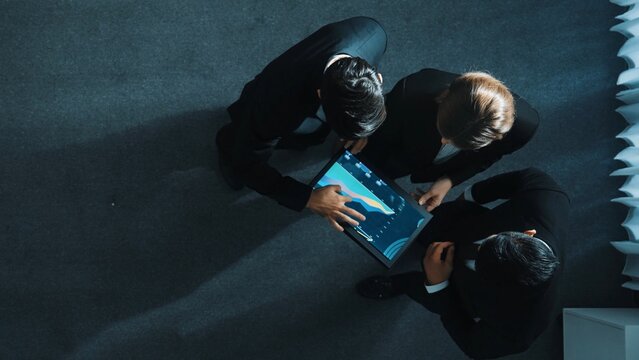 Top down aerial view of professional businessman joined a team and shake hands with executive manager. Smart marketing team working together to analyze stock investment data from tablet. Directorate.