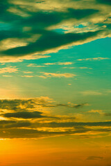 Obraz premium Cinematic vertical sunset sky with vibrant teal and orange clouds, perfect for social media mobile background and atmosphere.