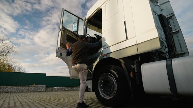 Truck driver getting into a semi truck cabin