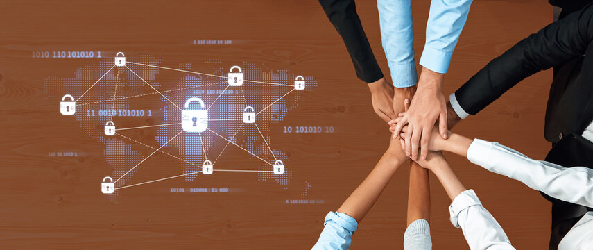 A diverse group of business professionals join hands around a conference table, symbolizing collaboration while a digital security concept enhances the theme of global data protection. Trope - Powered by Adobe