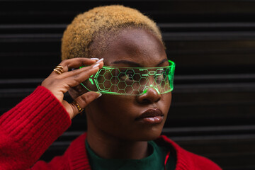 Young black woman wearing glowing augmented reality glasses, engaging with future technology