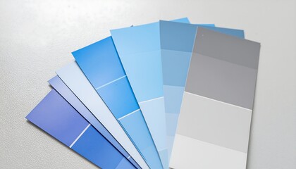 Fanned selection of blue and gray paint swatches, displaying diverse shades for interior design, home renovation, and decorating projects to choose the ideal hue