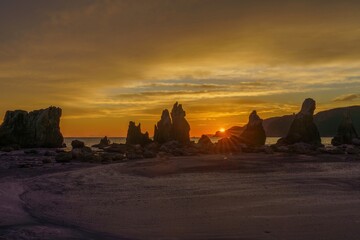 朝焼けに染まる幻想的な橋杭岩と光条のコラボ情景