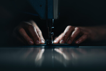 a man at work on a sewing machine. without a face.	
