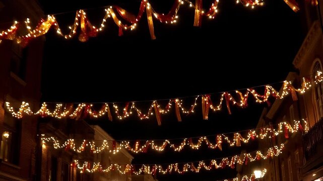 Decorative string lights hanging over a street at night  