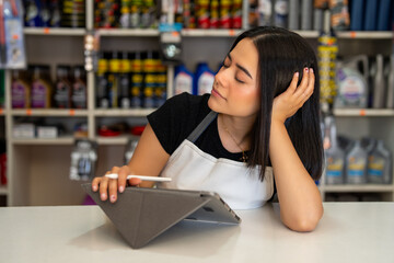 Young woman shopkeeper feeling bored and waiting for customers behind counter