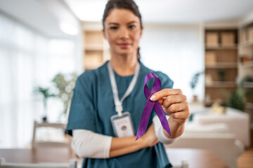 Healthcare professional holding purple awareness ribbon for support