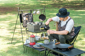 A middle-aged male camper camping solo on a grassy site at a campsite