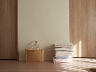 家のリビングの床にある編み鞄とバスタオルの様子