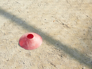 昼の運動場の地面にあるサッカーボール用のボールスタンドの様子