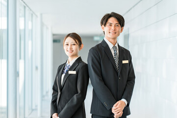 Young Asian male and female business people wearing suits (concierge, banker,)