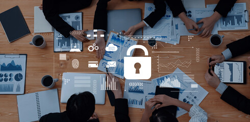 A dynamic business meeting focused on data security, featuring a collaborative team around a table with charts, laptops, and a lock icon for emphasis on protection and analysis. Trope