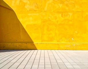 Sunny yellow wall and tiled floor with a bold triangular shadow
