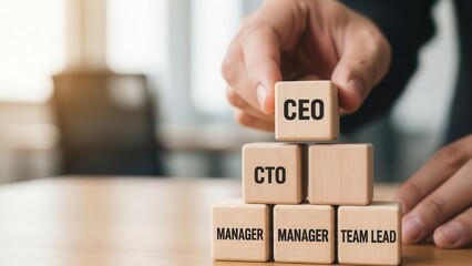 Wooden cubes representing leadership structure being positioned manually with fine shallow focus and softly diffused background