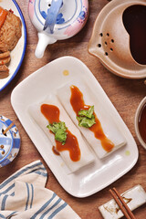 Steamed rice rolls in a dish  on wooden table 