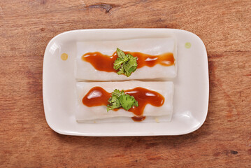 Steamed rice rolls in a dish  on wooden table 