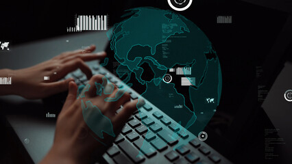 A close-up view of hands typing on a keyboard with a digital globe overlay and data visualizations on the screen, representing technology and global connectivity in a modern workspace. Xenic