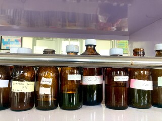 amber glass reagent bottles with chemical labels on a laboratory shelf