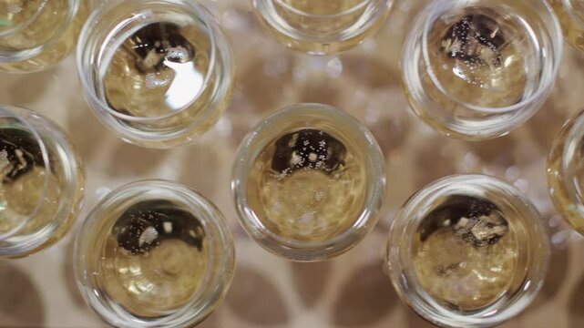 規則的に並べたグラスに注いだシャンぺーン　泡のたったスパークリングワイン　パーティー・アルコール