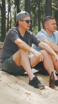 Caucasian Men outdoors enjoying, Friends sharing drinks outside happily, Men relaxing and drinking outdoors on gentle slope, Groups of men and friends happily relaxing with drinks on scenic outdoors
