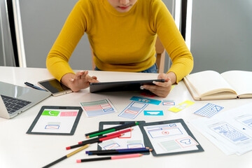 Young adult Asian woman create user interface mobile application user experience tablet office workspace creative professional digital art production