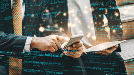 Two business professionals engaged with a smartphone and tablet, surrounded by a digital code background, representing the fusion of technology and workplace collaboration. Xenic