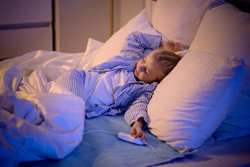 Cute little girl sleeping on electric heating pad in bedroom at night © Pixel-Shot