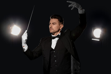 Young male conductor on dark blue background