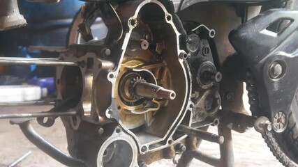 motorcycle engine being disassembled into the magnet block and cylinder sections - Powered by Adobe