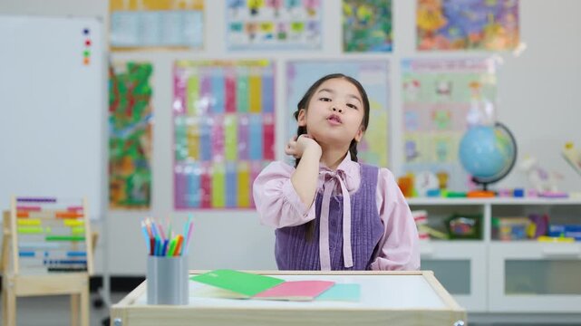 Young Girl Counting on Fingers in Classroom Setting