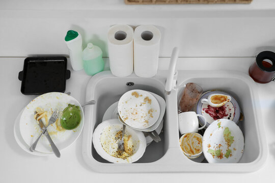 Heap of dirty dishes in sink at kitchen, top view