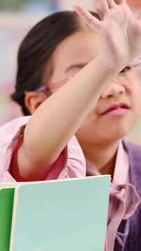 Young Girl in Pink Glasses Making Stop Gesture in Classroom