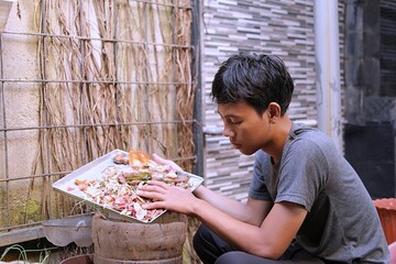 Young Gen Z individual composting kitchen waste at home, practicing sustainable living and eco-friendly habits to reduce household waste and support environmental awareness.