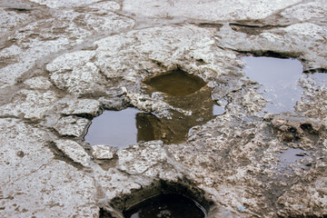 Wet ground surface with puddles after rain close up