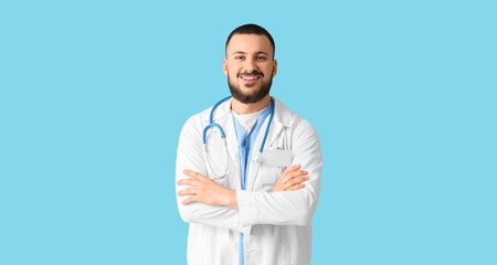 Smiling male doctor on blue background