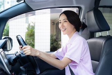 車で訪問介護をするミドルの女性介護士
