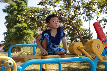 Portrait of a children in a park, A 3-year-old boy is happily walking in the park, wearing an Asian-style blue and white shirt.
