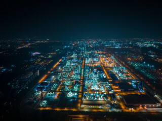 Aerial Night View of Glowing Industrial Complex with Pipelines