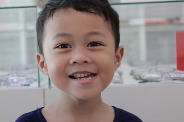Portrait of a children in a park, A 3-year-old boy is happily walking in the park, wearing an Asian-style blue and white shirt.