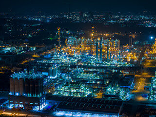 Aerial Night View of Glowing Industrial Complex with Pipelines
