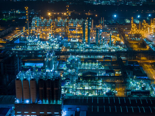 Aerial Night View of Glowing Industrial Complex with Pipelines