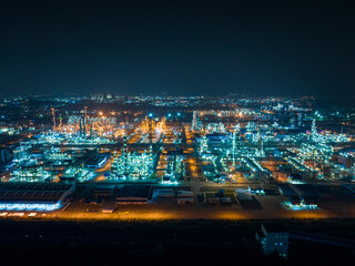 Aerial Night View of Glowing Industrial Complex with Pipelines