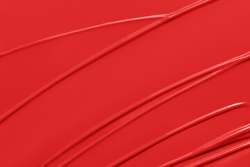 Red lipstick texture background.  Creamy lip makeup product or paint swatch. Lliquid lipstick or lip gloss smear closeup