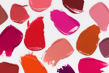Lipstick shades swatches. Color makeup cream smudges on light gray background. Cosmetic smears collection