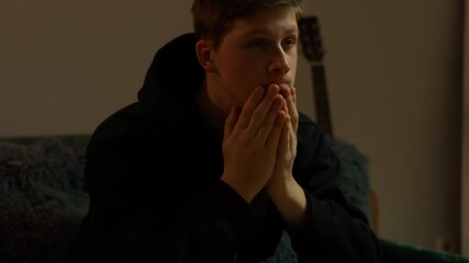 Male musician covers face in moment of stress showing deep emotional tension and psychological strain