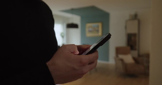 Close-up of hands typing on a smartphone in a cozy home interior&mdash;ideal for messaging, texting, remote communication, social media, and everyday digital lifestyle.