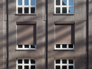 Modern Urban Residential Building Facade with Symmetrical Windows and Geometric Brick Design in Daylight