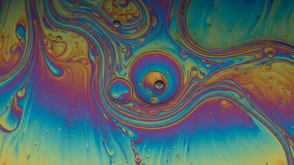 Vibrant iridescent oil and water swirls create a mesmerizing abstract rainbow pattern.